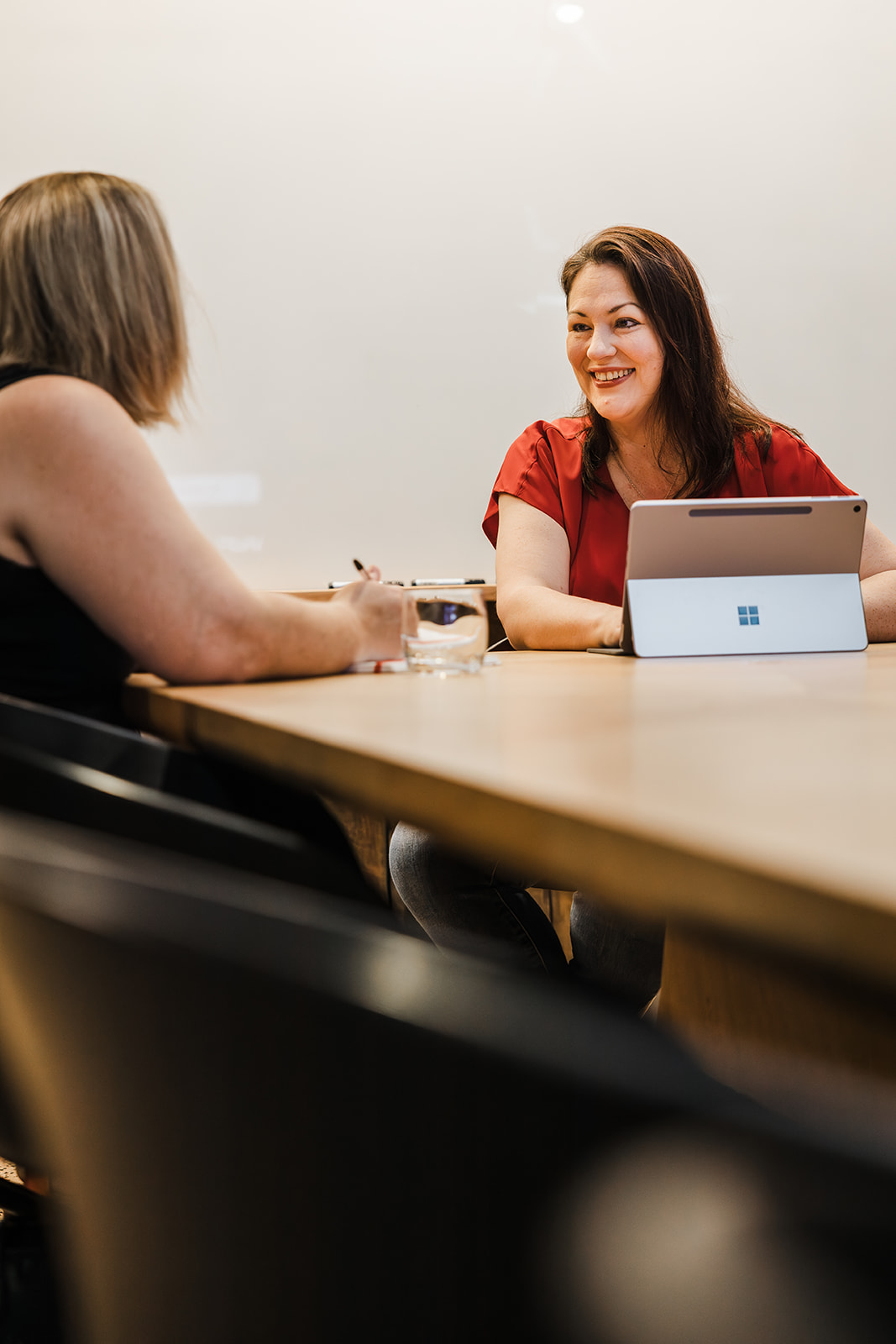 Alanna speaking to a client while using her laptop.
